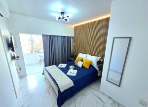 a bedroom with a blue bed and a mirror at Marble Coast Studio Apartment in Larnaca