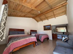 two beds in a room with a couch and a tv at Hotel Mi Lindo Chihuahua in Areponapuchi