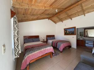 two beds in a room with a tv and a couch at Hotel Mi Lindo Chihuahua in Areponapuchi