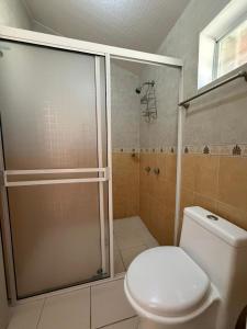 a bathroom with a toilet and a shower with a glass door at Hotel Mi Lindo Chihuahua in Areponapuchi