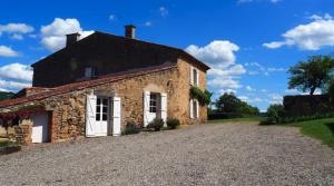 an old stone house with a gravel driveway at Ferme de Jeanleix in Sauxillanges