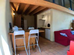 a kitchen with a table and two white stools at Ferme de Jeanleix in Sauxillanges