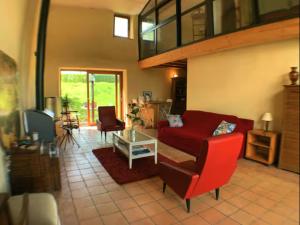 a living room with a red couch and a table at Ferme de Jeanleix in Sauxillanges