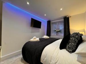 a bedroom with a large bed with a blue lighting at Modern Central St Albans Maisonette Free Parking Sleeps 4 Fast Wifi in St. Albans