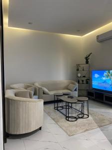 a living room with a couch and a tv at شقق المصيف الفندقيه in Hafr Al-Batin