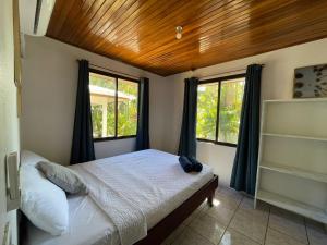 a bedroom with a bed and two windows at Koba Apartments Santa Teresa in Santa Teresa Beach +68 photos