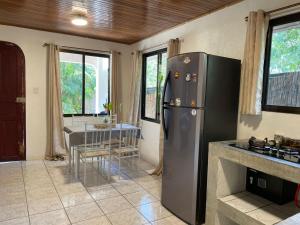 a kitchen with a stainless steel refrigerator and a table at Koba Apartments Santa Teresa in Santa Teresa Beach