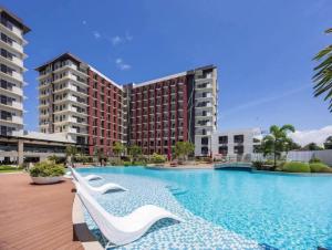 a swimming pool in front of a building at Primeworld District with Balcony near Mactan Airport in Pajak