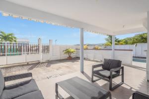 a patio with a couch and a chair and a table at Villa 2 chambres, Jacuzzi et Piscine in Maximin