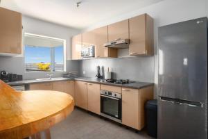 a kitchen with stainless steel appliances and a wooden table at Villa 2 chambres, Jacuzzi et Piscine in Maximin