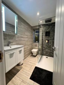 a bathroom with a shower and a sink and a toilet at Modern Central St Albans Maisonette Free Parking Sleeps 4 Fast Wifi in St. Albans