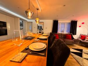 a living room with a wooden table with wine glasses at Modern Central St Albans Maisonette Free Parking Sleeps 4 Fast Wifi in St. Albans