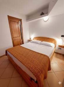 a bedroom with a bed with a brown blanket on it at Lo chalet di Lucky in Campodolcino
