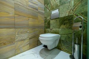 a bathroom with a toilet and wooden walls at LUVERDE HOTEL Sarkand in Almaty