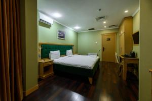 a hotel room with a bed and a desk and a table at LUVERDE HOTEL Sarkand in Almaty
