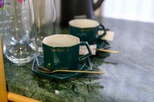 two green cups and teaspoons on a table with glasses at LUVERDE HOTEL Sarkand in Almaty +14 photos