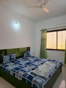 a bedroom with a bed with a blue and white blanket at 1 Bhk Mayra Homes in Raipur