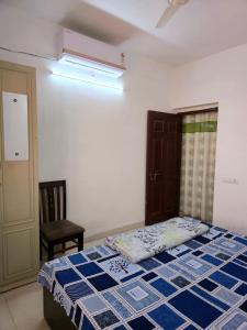 a bedroom with a bed and a chair at 1 Bhk Mayra Homes in Raipur