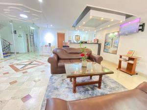 a living room with leather furniture and a table at Gran Hotel Cali in Cali