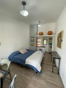 a bedroom with a bed and a table and a chair at Casa laberinto, Entre cerros, cómoda cama de 2x2 in Salta