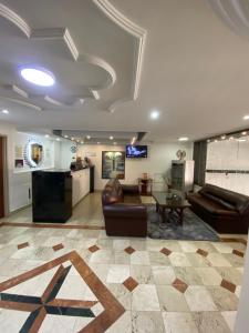 a lobby with two leather chairs and a table at Gran Hotel Cali in Cali