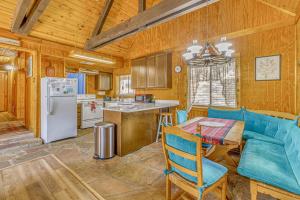 a kitchen and dining room with a table and blue chairs at Peaceful & Private Cloudcroft Cabin with Deck! in Cloudcroft