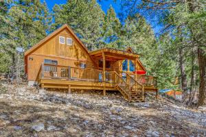 a cabin in the woods with a large deck at Peaceful & Private Cloudcroft Cabin with Deck! in Cloudcroft