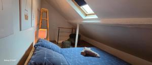 a bedroom with a blue bed in a attic at La cachette de l'Alpiniste in Fontainebleau +6 photos
