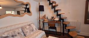 a living room with a couch and a mirror at La cachette de l'Alpiniste in Fontainebleau