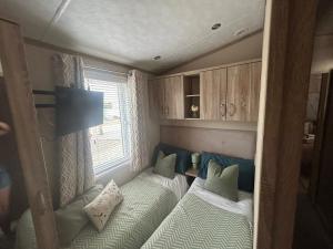 a small room with two beds and a window at sunset luxury lakeside lodge with hot-tub,3 bedrooms, pet friendly in Tattershall