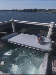 a bed on the back of a boat in the water at sunset luxury lakeside lodge with hot-tub,3 bedrooms, pet friendly in Tattershall