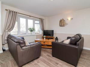 a living room with two leather chairs and a television at Castle View Lodge in Ilfracombe