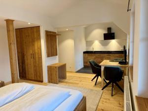a bedroom with a bed and a desk with a computer at Vogelbauer Apartments in Egling
