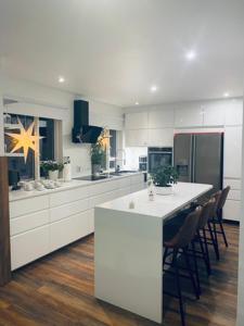 a large kitchen with a white counter and chairs at Easy Stay in Keflavík +34 photos