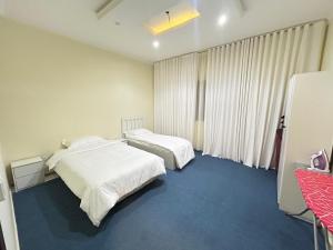 a hotel room with two beds and a window at Olive Residence Madinah in Medina