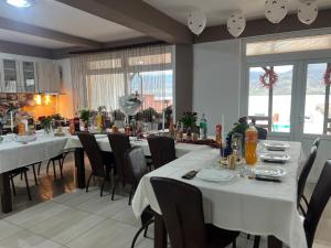 a dining room with white tables and chairs at Casa Alle in Eşelniţa
