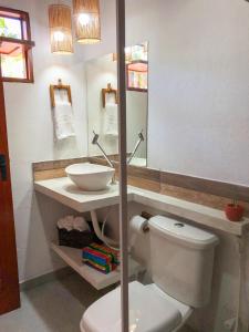a bathroom with a toilet and a sink and a mirror at Chalé Pitanga in Pôrto de Pedras +3 photos