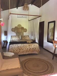 a bedroom with a bed and a rug in a room at Chalé Pitanga in Pôrto de Pedras