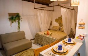 a living room with a couch and a table with plates on it at Chalé Pitanga in Pôrto de Pedras