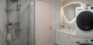 a bathroom with a shower and a sink and a mirror at EV Apartment with free parking place in Volos +10 photos