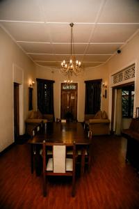 a dining room with a table and chairs and a chandelier at Hotel Mount Pleasant in Bandarawela