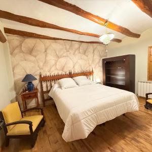 a bedroom with a large white bed and a chair at Cielos in Celadas