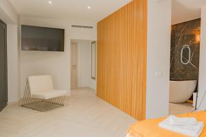 a bedroom with a bed and a chair and a tub at Ocean View Villa, Private Pool and Terrace in Santa Cruz