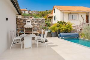 a patio with a table and chairs next to a swimming pool at Ocean View Villa, Private Pool and Terrace in Santa Cruz
