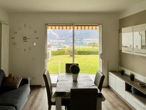 a living room with a table and a large window at BADIA del LAGO CLUSANE in Clusane sul Lago
