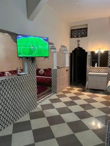 a living room with a tv and a checkered floor at spacious ground floor apartment in Taroudant