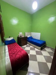 a bedroom with two beds and a checkered floor at spacious ground floor apartment in Taroudant