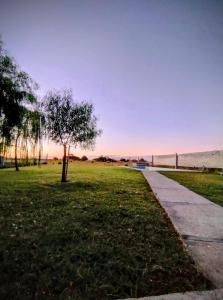 a sidewalk in a park with a tree in the grass at Refugio del sol Erezcano in Eréscano