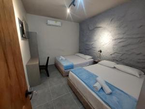 a hotel room with two beds and a desk at Hotel Kyros by 70 in Medellín