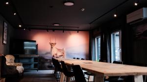 a room with a table and a picture of a deer on the wall at Sov Lodge in Vågåmo